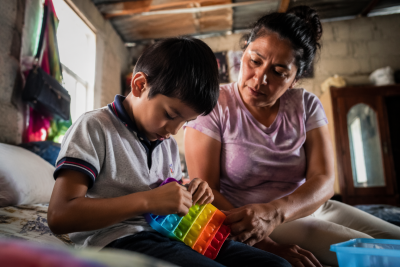 Madre observa con preocupaci&oacute;n a su hijo con autismo mientras juega con un objeto sensorial en su hogar en La Paz Baja California Sur